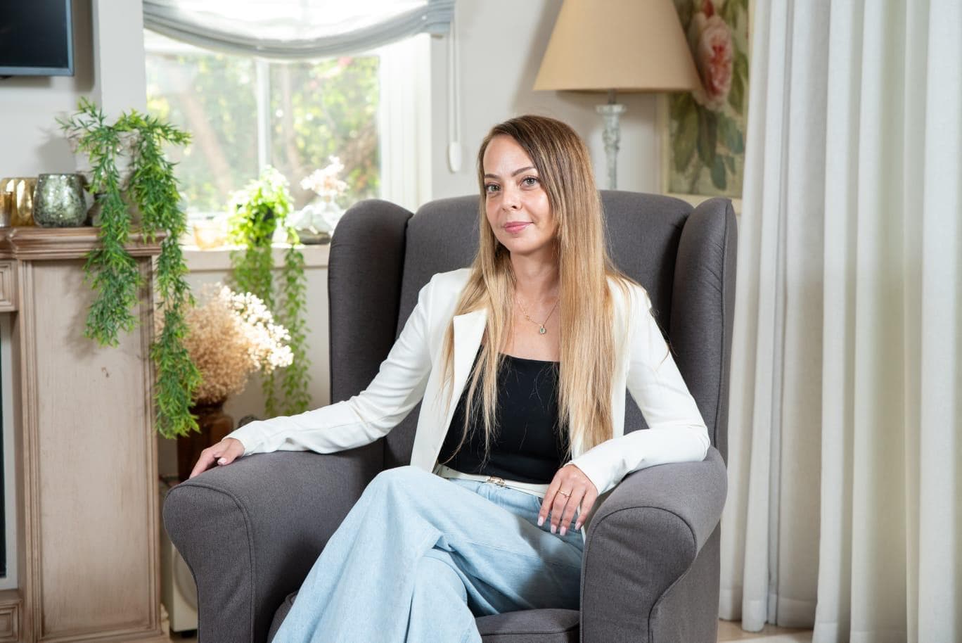 יעל שלום - עו"ס קלינית ופסיכותרפיסטית, יושבת על כורסה